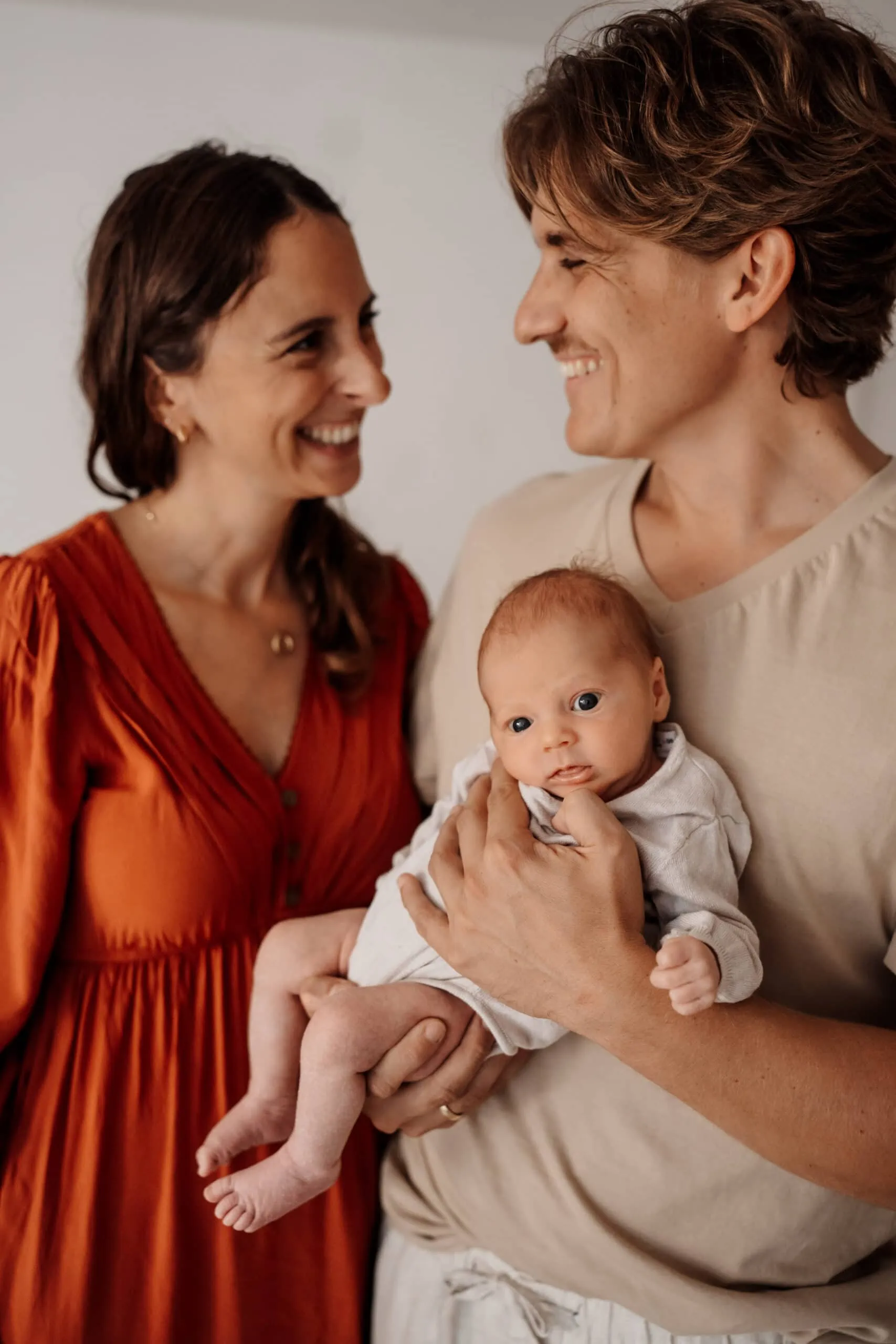 Familienfoto mit Mama und Papa und Neugeborenem sitzend auf dem Hocker im Fotostudio in Rangendingen bei Monja Drössel von Fotografie Herzseeligkeit