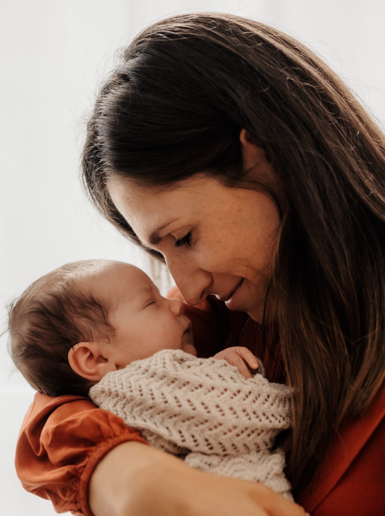 Mama hält neugeborenes Baby sanft im Arm im Fotostudio Fotografie Herzseeligkeit von Monja Drössel in Rangendingen