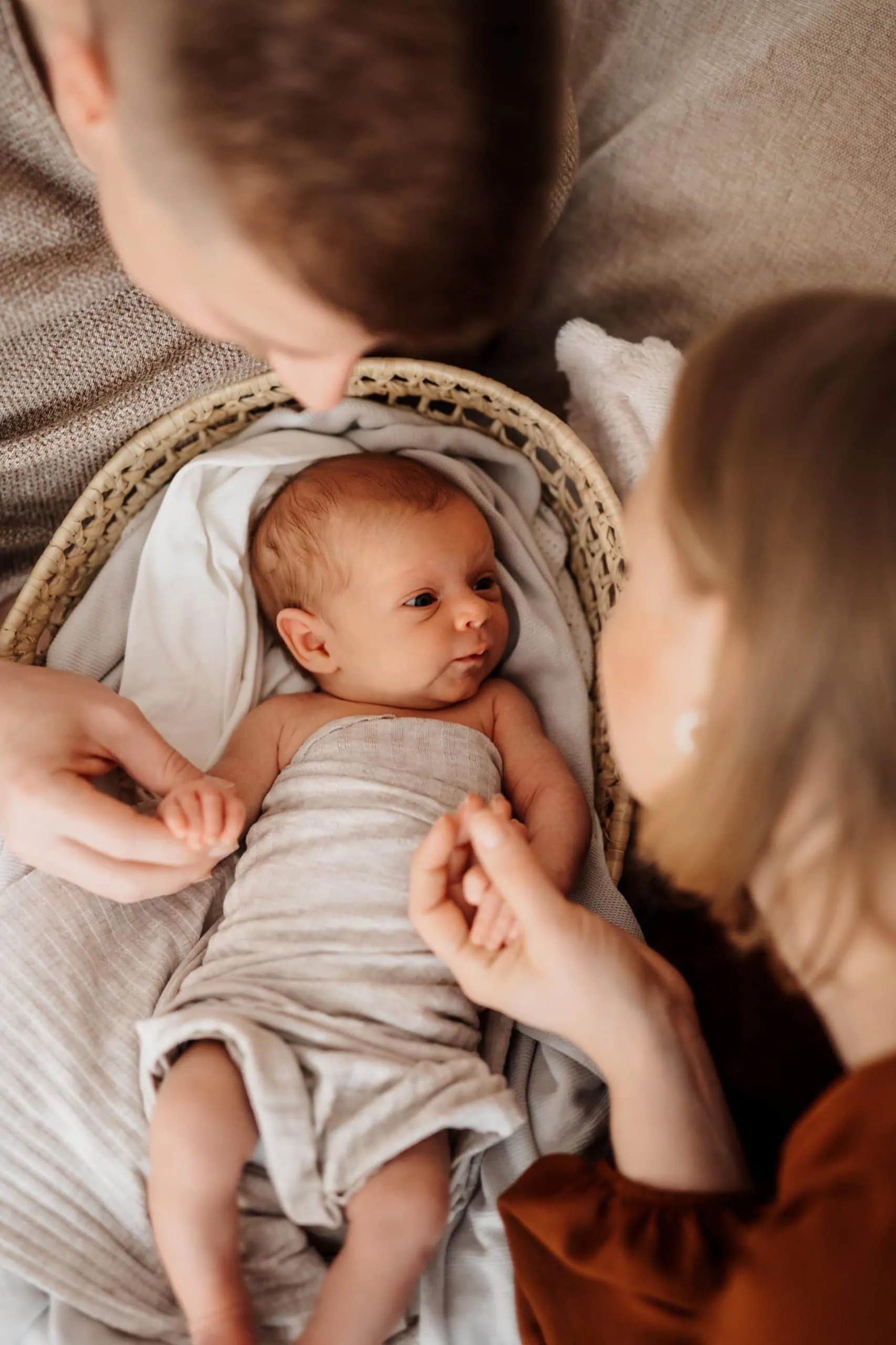 Neugeborenes Baby liegend zwischen Mama und Papa im Fotostudio von Monja Drössel in der Nähe von Rottenburg am Neckar